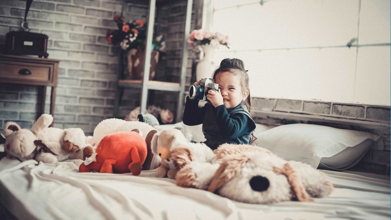 little girl smiling on a bed